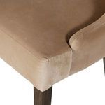 Low angle showing close-up of dark tapered parawood leg beneath taupe velvet seat