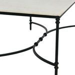 Close-up view of curved black metal legs and intersecting supports of coffee table frame