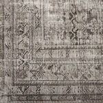 Close-up on rug corner with detailed geometric and floral vintage-inspired pattern