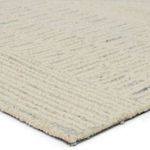 Close-up of rug corner showing wool texture and tufted cream and gray stripes