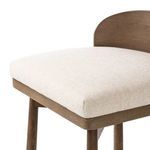 Close-up front corner of thick cushioned seat fabric and wood frame edge