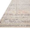 angled side view emphasizing rug’s low pile and woven texture with faded traditional pattern