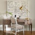 Tamara Arm Chair placed at a wood desk with gold lamp and abstract art on wall