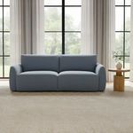 Callie Sofa in living room with natural light, beige carpet, and side table with vase