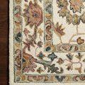 Close-up of the Padma rug corner on wood floor highlighting intricate hooked wool pattern and color variations