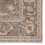 Close-up on corner with detailed floral motifs and border pattern in gray and cream tones
