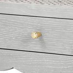 Close-up detail of gold metal knob on drawer of white lacquered side table