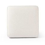 Top-down view of ottoman showing square shape with piped edges and textured white upholstery