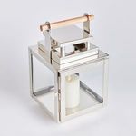Outdoor lantern with lit candle inside on white background, front-facing