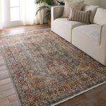 Zakaria rug placed in a living room under a cream sofa on wood floor with soft natural light