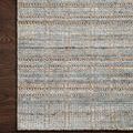 Close-up of Jamie Natural Sky Rug corner on dark hardwood floor, highlighting looped texture and color variation