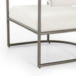 Close-up on metal base frame corner with tubular legs and textured seat fabric