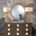 Room scene with two lamps flanking mother of pearl mirror above dresser displaying the decorative boxes