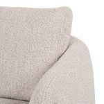 Close-up focusing on seat pillow edge with subtle texture of bouclé material
