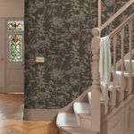 Esther Wallpaper installed on wall by staircase with beige wood banister and stained glass window
