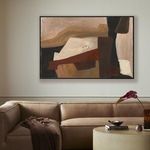 Painting mounted on wall above brown leather sofa with beige walls and modern living room décor