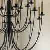 Detailed view of middle lower section of Erika chandelier highlighting aged iron arms and candelabra holders