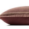 Side profile of pillow shows smooth solid burgundy fabric on back and striped textured front