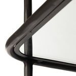 detail of gently rounded gunmetal frame supporting tempered glass with visible leg protector