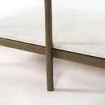 Close-up of bottom brass frame joint beneath a white marble shelf