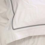 Close-up of duvet pillow corner highlighting smooth bamboo sateen fabric and detailed grey edge piping