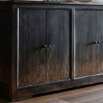 close-up of cable hole in rear cabinet panel, surrounded by dark wood grain finish