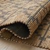 Curled corner of rug highlighting woven fibers and thickness with underside peeked