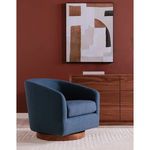 Side view of Oscy chair in room with red wall, wooden storage unit, and beige rug