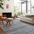 Yeshaia Grey Charcoal Rug styled in bright living room with light sofa and wood furniture