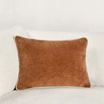 Pillow styled on white sofa contrasting warm brown velvet against light upholstery