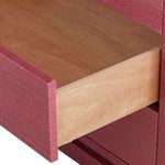 Open middle drawer showing natural wood sides and bottom inside the red dresser framework