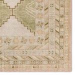 Detailed close-up of rug corner focusing on layered border patterns with floral and geometric motifs in muted tones