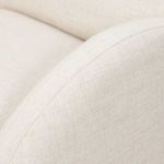 Close-up showing the curved armrest’s seam and upholstery texture