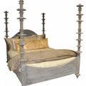 King bed with tall, hand-carved posts featuring variegated mahogany discs, pale weathered whitewashed finish.