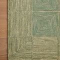 Close detail of Francis Green Natural Rug's corner with textured diamond and grid pattern on wood floor