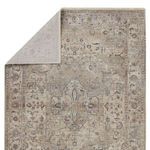 Partially folded rug showing the backside in lighter cream color and the detailed medallion design on front