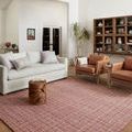 Polly Berry rug styled in modern living room with white sofa, leather armchairs, and wooden cabinet