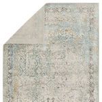Top view of rug with one corner flipped over revealing a solid light gray backing