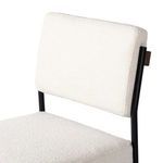 Close-up view of Benton Stool white fabric backrest with black iron frame and oak back support
