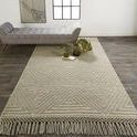 Phoenix Natural Tan Rug styled in room with wooden floor, tufted gray bench, and decorative vases on rug