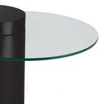 Close-up of clear glass top edge and glossy black cylindrical base of side table