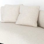 Close-up showing curved armrest and cushions with visible fabric stitching and weave