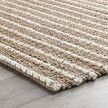 Side angle view of rug laid flat over wood floor highlighting thickness and pattern continuity
