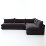 Side view focusing on rounded cushion edges and flat base of sectional in dark charcoal fabric