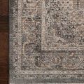 Close-up of rug corner displaying detailed pattern and texture against dark wood flooring