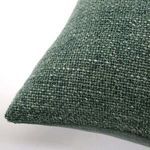 Close-up of moss green pillow corner showing detailed woven cotton texture