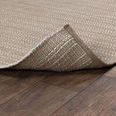 Back corner of rug lifted to reveal weave and thickness on wood floor background