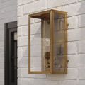 Royster Outdoor Wall Sconce in antique brass finish mounted on white brick wall in outdoor setting
