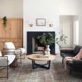 Rug placed in a modern living area featuring vaulted ceiling and minimalist furnishings around a circular table.
