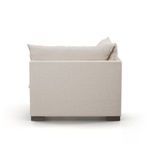 Back side showing straight lines of upholstery and cushion depth on dark block feet